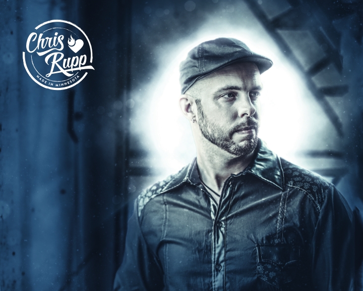 Chris Rupp in a blue-toned portrait wearing a cap