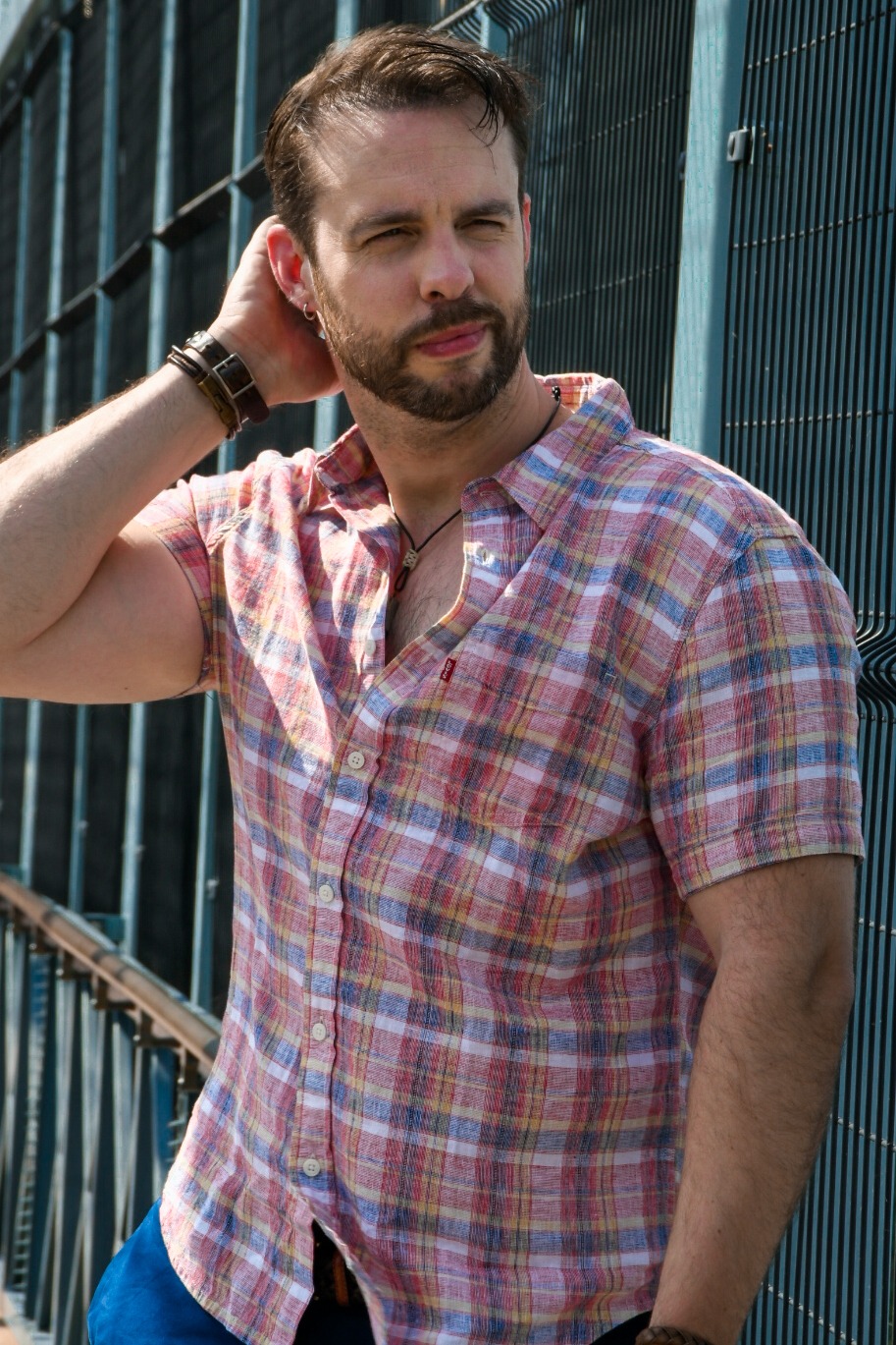 Chris Rupp in a plaid shirt by a turquoise fence